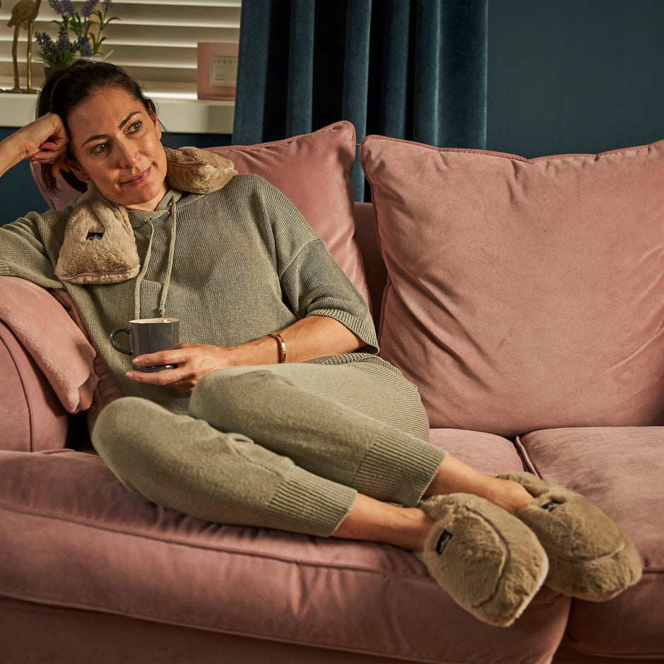 Woman relaxing with her microwave neck warmer and boots