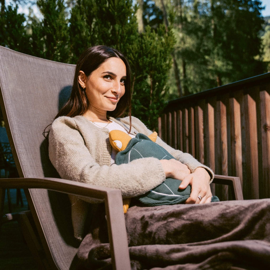 Woman sitting in chair with turtle hot water bottle