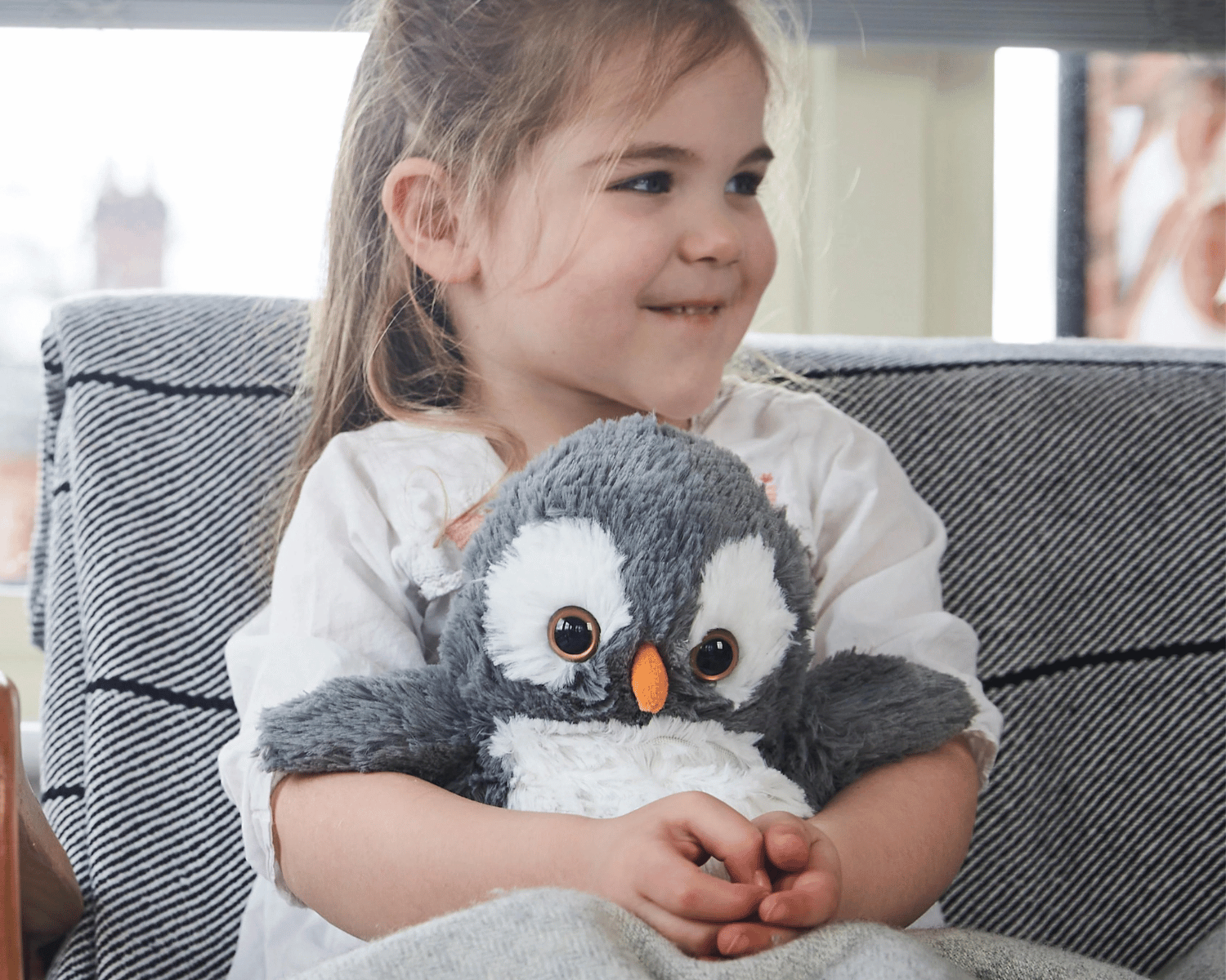 Girl holding microwave penguin toy